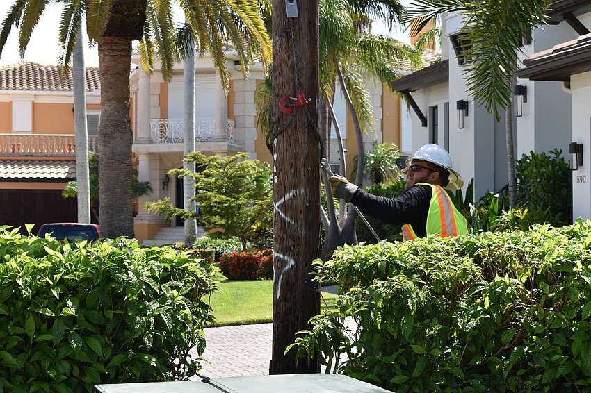 On July 22, Volt Power Co. crews worked to remove light poles from Birdie Lane. Groudman Jared Truxillo is pictured here at the base of the wooden pole.