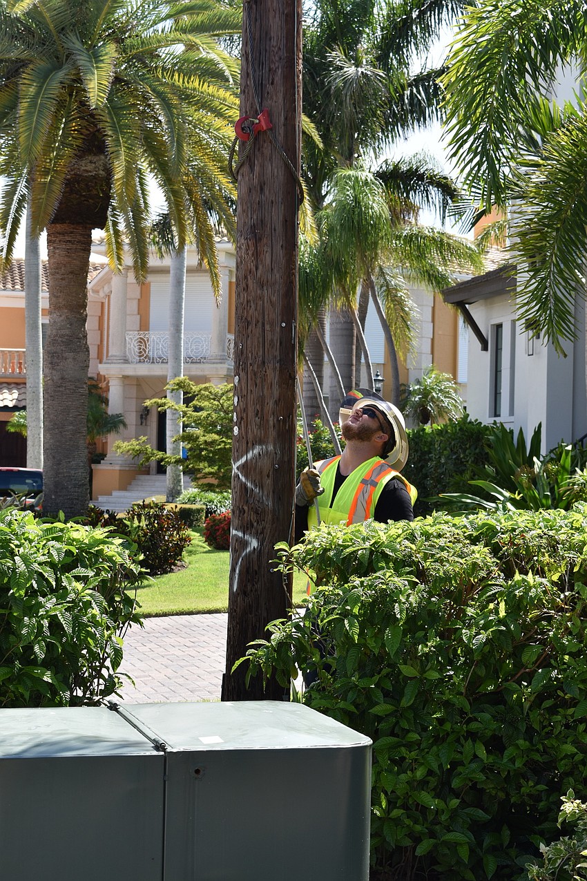 On July 22, Volt Power Co. crews worked to remove light poles from Birdie Lane. Groudman Jared Truxillo is pictured here at the base of the wooden pole.