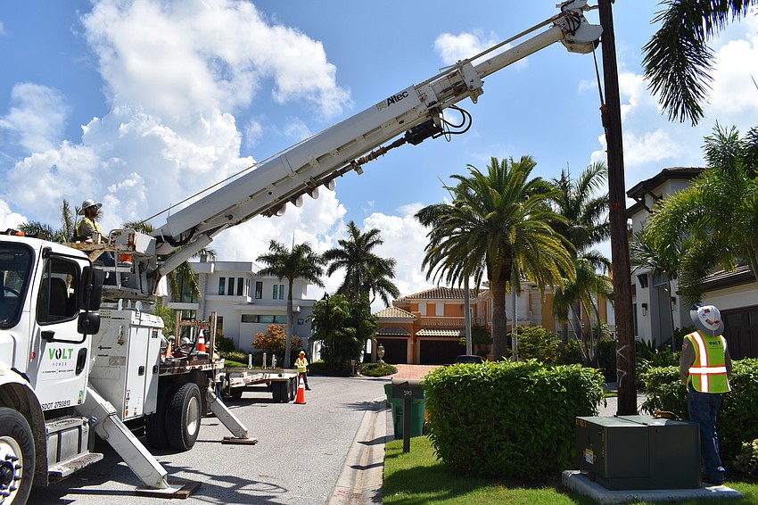 On July 22, Volt Power Co.'s Heston Braddock and Jared Truxillo work to remove a light pole from Birdie Lane.