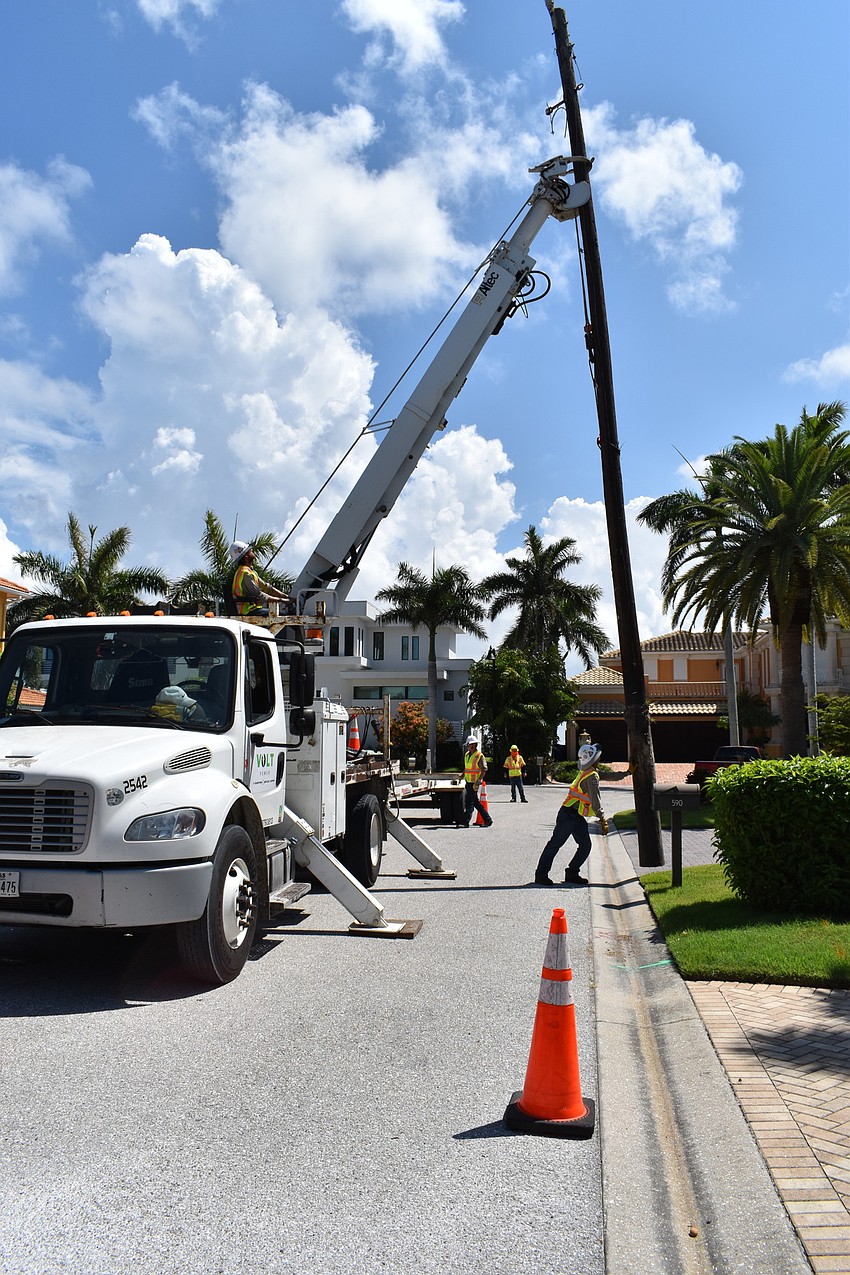 On July 22, Volt Power Co.'s Heston Braddock and Jared Truxillo work to remove a light pole from Birdie Lane.