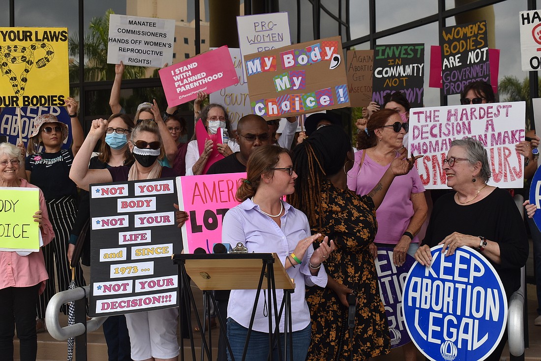 Protesters clap and cheer at the end of a press conference to wrap up a protest against the possibility of increased abortion restrictions in Manatee County at a commission meeting Tuesday.