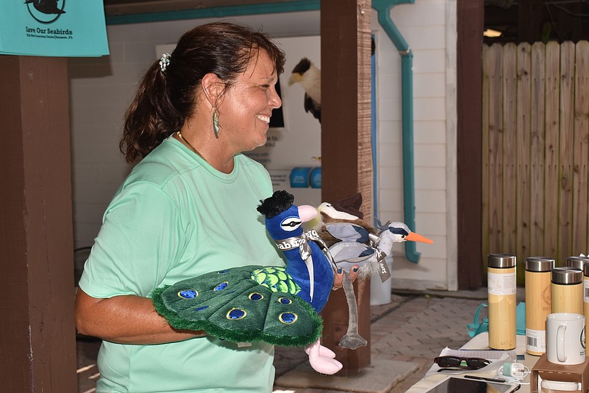 Volunteer Heather Sellers shows off the bird toys for purchase.