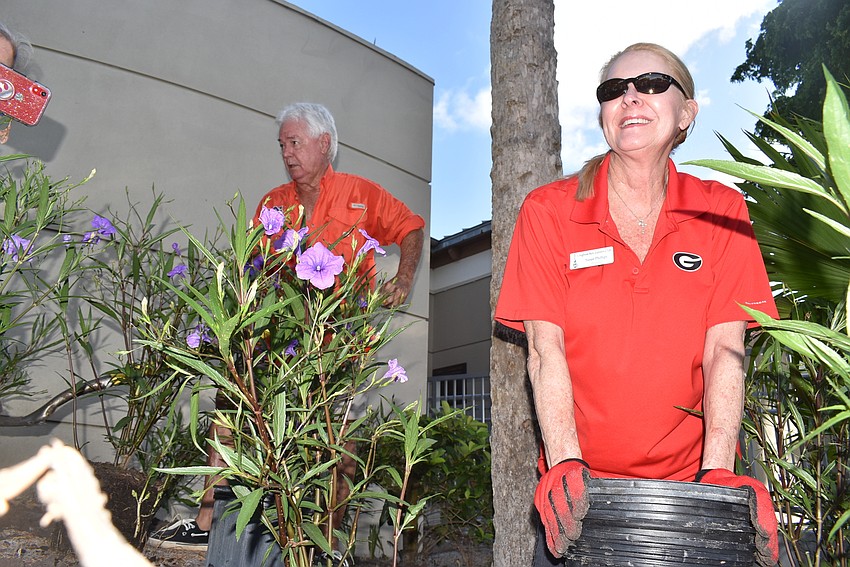 Susan Phillips gathers empty plant buckets.