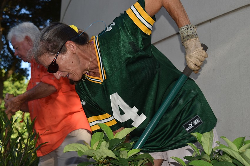 Cyndi Seamon lifts another shovel of dirt out to make way for a plant.