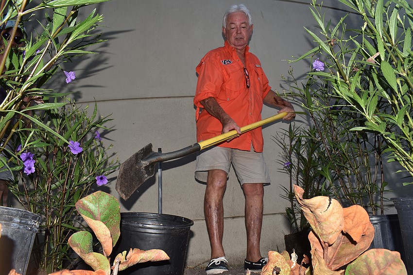 Jim Brown dumps a shovel of dirt away.