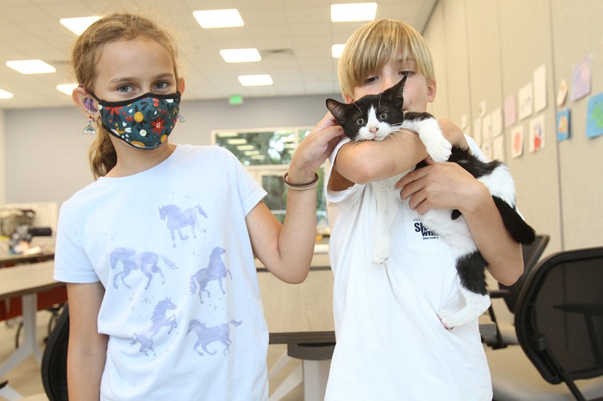 Paloma Sirianni, 9 and Ean Watson, 8 play with a kitty.