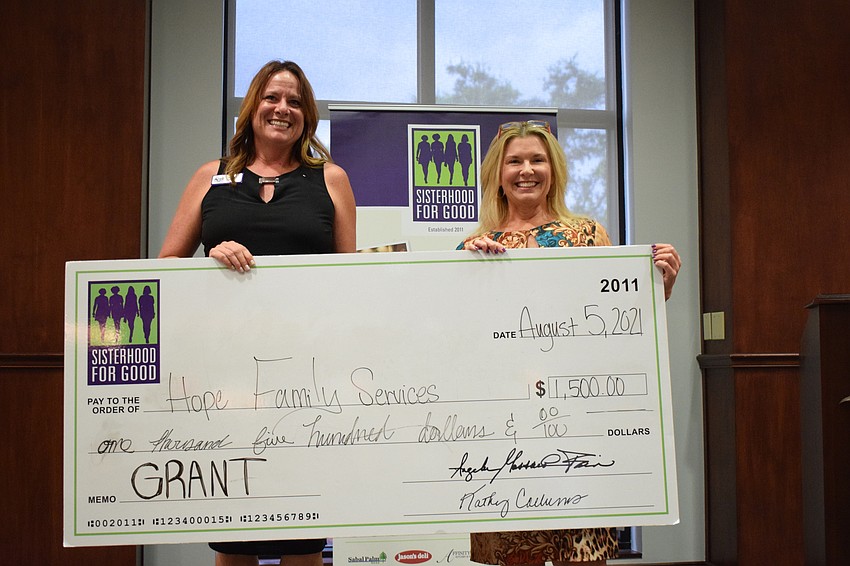 Stacey McKee with HOPE Family Services is grateful for the $1,500 grant she accepted from Sisterhood for Good's Lorri Kidder. The grant will be used to feed residents at Hope Family Services' Emergency Safe Shelter.