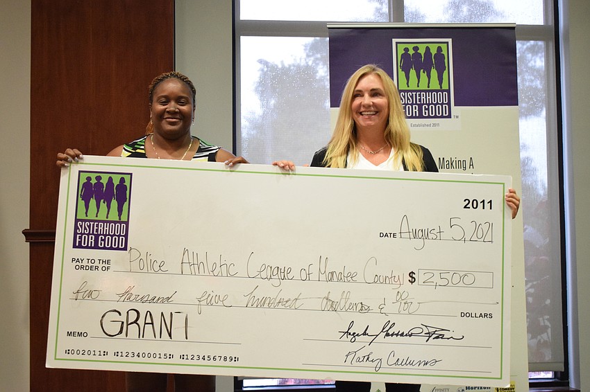 Deputy Francine Houston accepts a grant on behalf of the Police Athletic League of Manatee County from Sisterhood for Good's Jill Maciag. Houston went through the program herself and shared the impact  it has on participants.