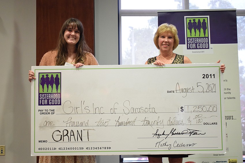 Jordana Terrell with Girls Inc. of Sarasota is happy to accept a grant from Sisterhood for Good's Kathy Collums.