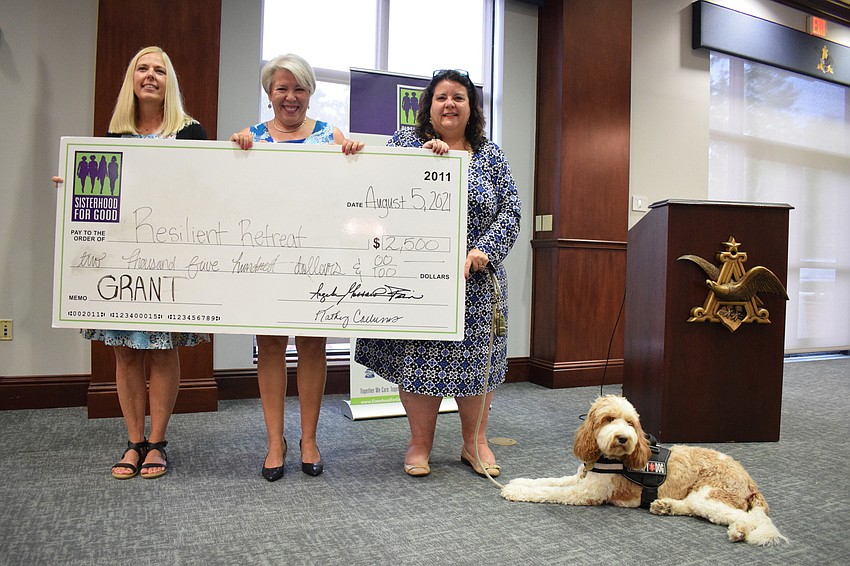 Terri Stern (center) with Sisterhood for Good presents a grant to Resilient Retreat's Julie Anderson, Lisa Intagliata and Journey, who is a therapy dog for Resilient Retreat.
