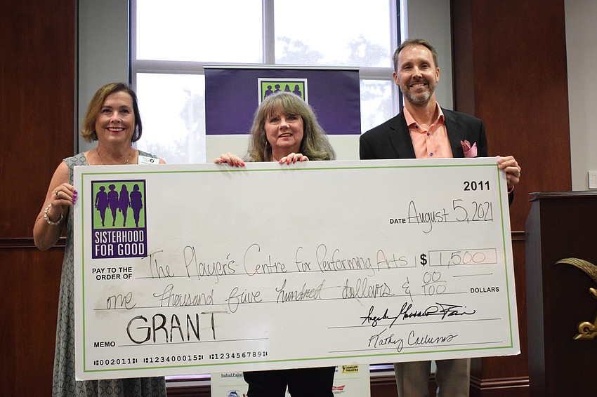 Donna DeFant, the chair of the Player's Centre for Performing Arts' board, and William Skaggs, the CEO of the nonprofit, accepts a grant from Sisterhood for Good's Liz Brookins (center).