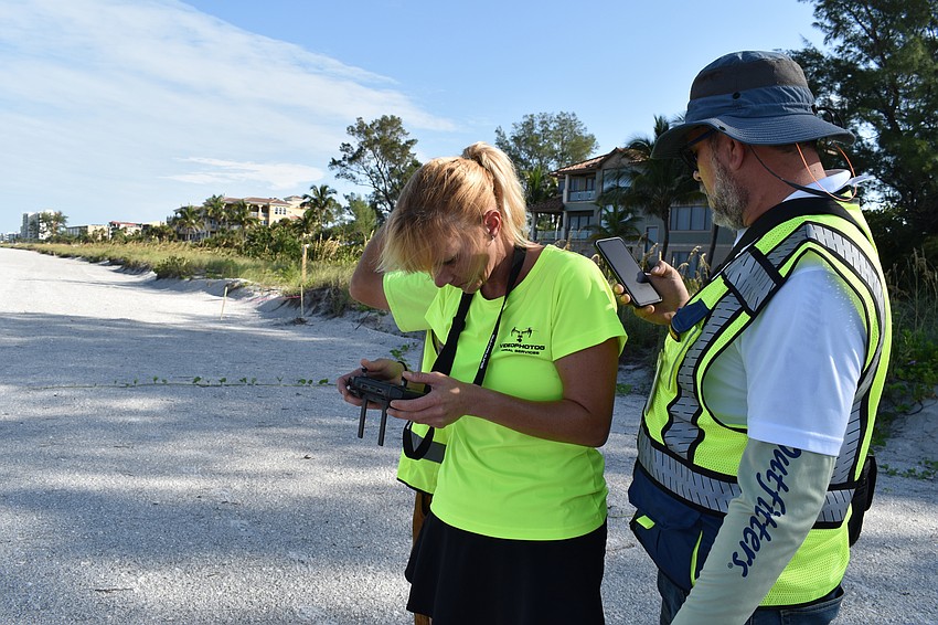 Melissa Matisko watches her screen while flying the DJI Mavic 2 Pro. Hjalmar Pachas (far right) looks on.