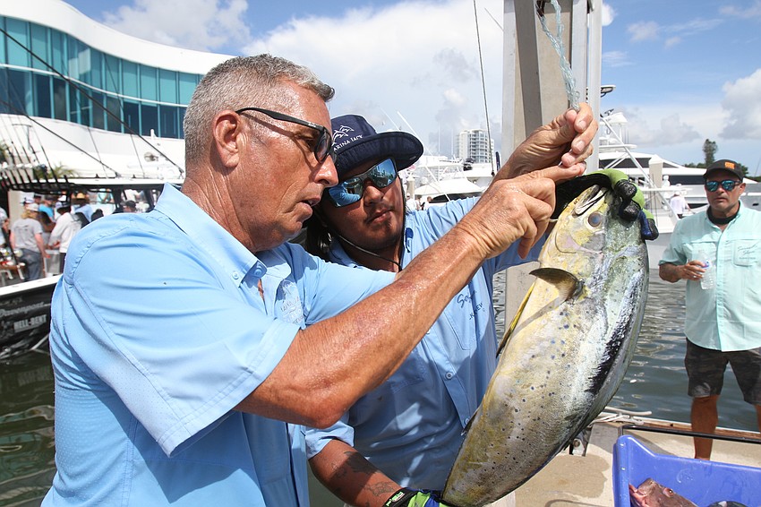 Bill Spitler and Levi Palacios work to hook a fish.