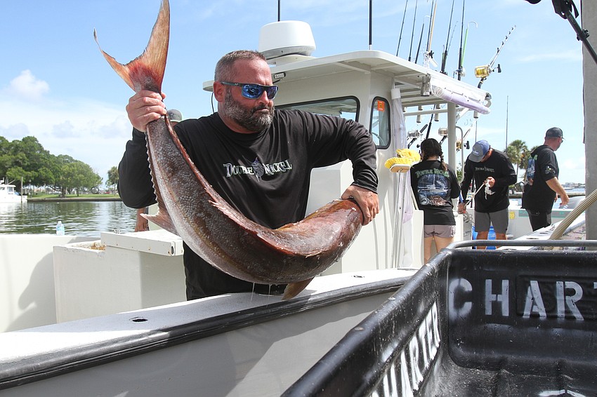 Jason Angelo gets a fish into the container.
