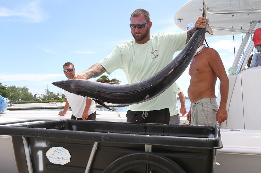 Tyler Chartand moves a fish to the container.