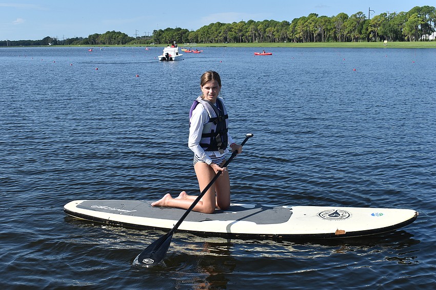 Waterside's Ella Berzins, 11, relaxes with some time on a paddleboard after finishing the kayak races. Berzins said using the paddleboard was her favorite part of the camp.