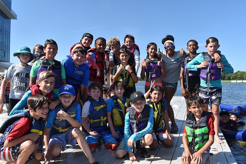 Campers and Counselor Zianna Williams of Sarasota hang out by the swimming pool section of the lake after kayak races. The 