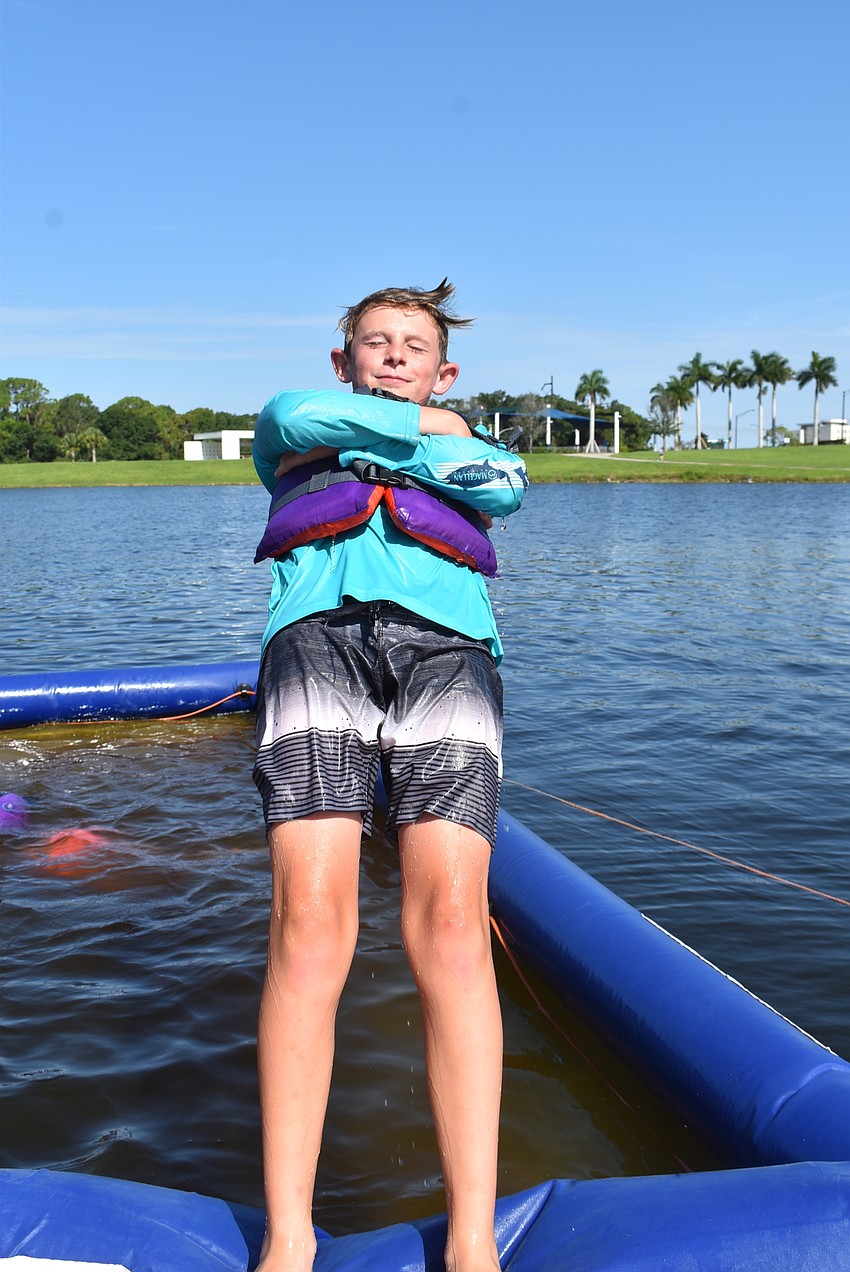 Sarasota's Brayden Lynch, 11, falls into the water after a long morning of racing kayaks and jumping into the lake. He said paddleboarding with friends was his favorite part of the week.