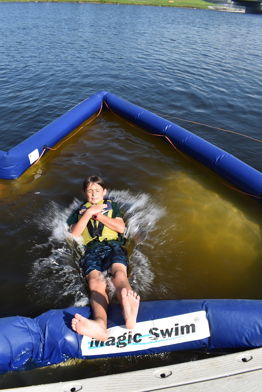 Lakewood Ranch's Blake Delaney, 8, cools off on a hot morning at Nathan Benderson Park by splashing into the swimming pool section of the lake. His favorite part of the camp was racing kayaks.