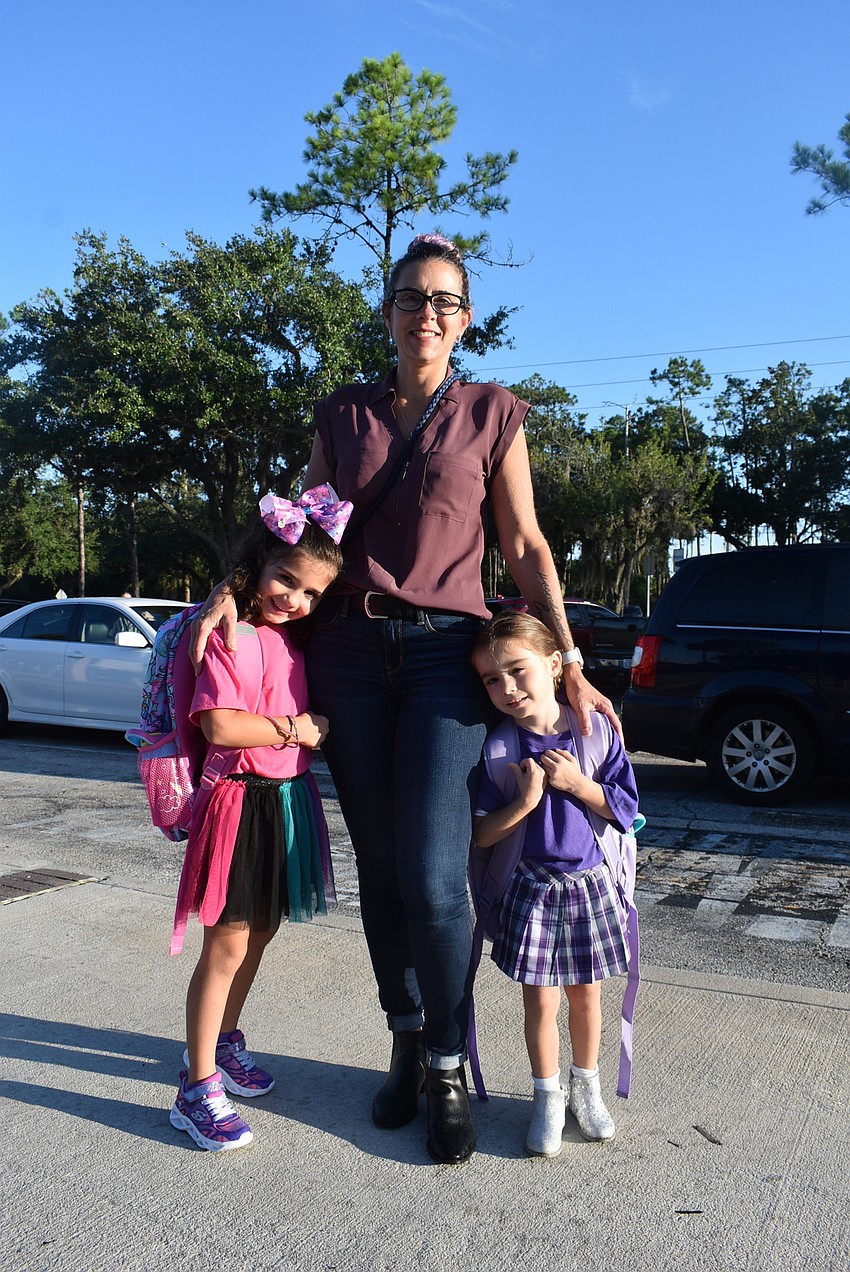 Amy House drops off first grader Zadie House and kindergartner Leenah House at Tara Elementary School. Zadie House says she is looking forward to playing on the school's playground.