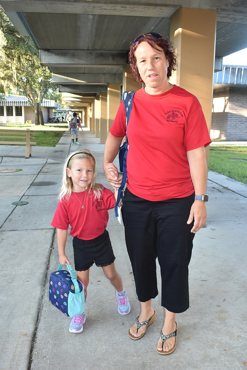 Tara Elementary School pre-K student McKinley Rogers is reluctant to step away from her mom, third grade teacher Jeanne Rogers, as she is led to her classroom. She is excited to finally be on campus with her mom.
