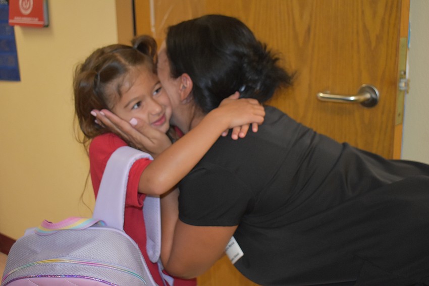 Ariah Wyrick receives a kiss from her mom, Madeline Wyrick, before her first day of kindergarten at Tara Elementary School. Madeline says she is very excited to do homework this year after doing some in pre-K last year.