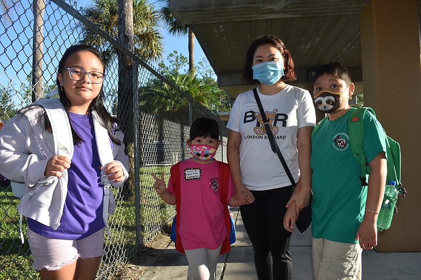 Fourth grader Kaitlyn Nguyen, kindergartner Elynn Nguyen, mom Lilly Nguyen and fourth grader Ethan Nguyen prepare to say goodbye before their first day of school. They are new to Tara Elementary School.