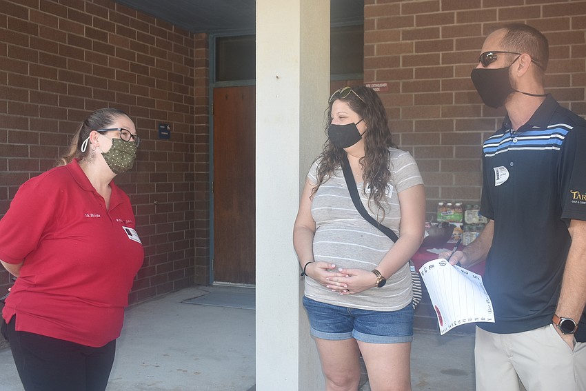 Brooke Williams, the director of Tara Elementary School's child care center, talks with Ashley and J.R. Rainer. The Rainers had just dropped off their son, Clayton Rainer, for his first day of kindergarten.
