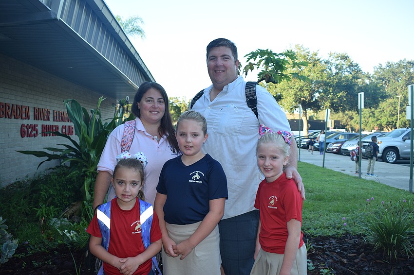 Laura Busenburg and her husband, Patrick Busenburg, drop off their kindergartner Daniella Busenburg, second grader Gabriella Busenburg and third grader Isabella Busenburg for their first day of school at Braden River Elementary.