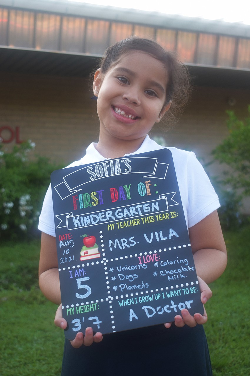Sofia Oliva, a kindergartner at Braden River Elementary School, marks her first day with a sign of fun facts about her. Oliva says she wants to be a doctor because doctors help kids.