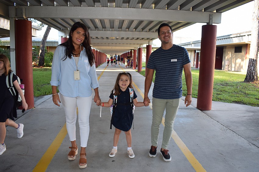 Claudia Lescano walks with her daughter Lia Lescano and her husband Daniel Lescano to Lia's classroom for the first day of kindergarten at Braden River Elementary School.