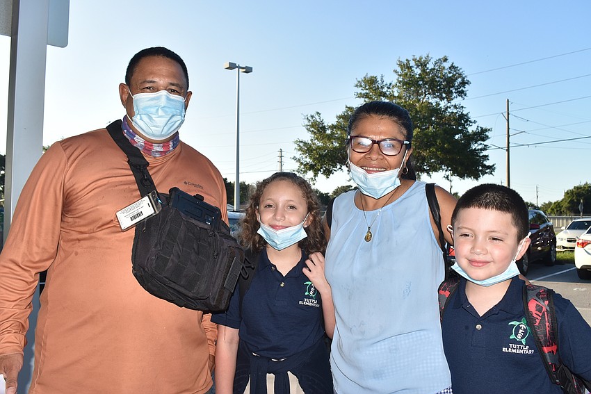 Pete, Reagan, Nelly and Roland Perry wait to get checked in so parents Pete and Nelly can accompany fourth-grader Reagan and second-grader Roland to class at Tuttle Elementary School.