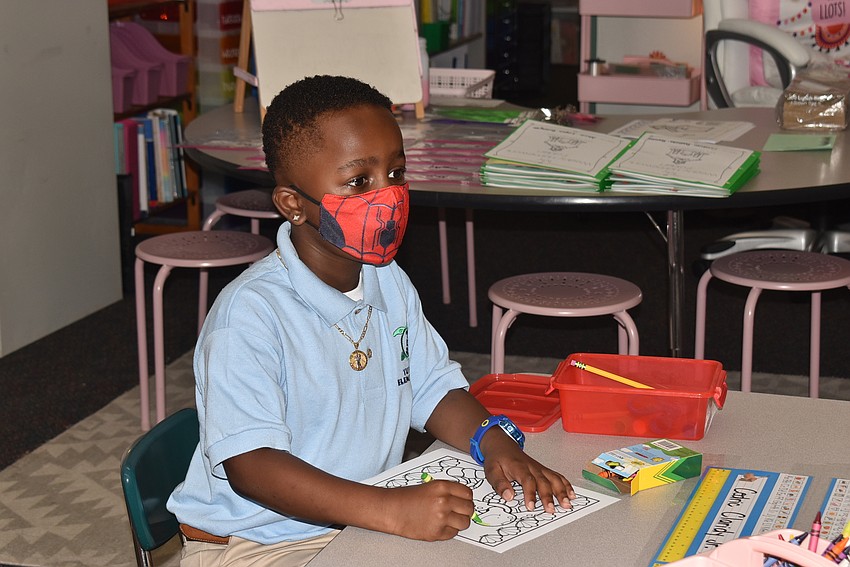 Cedric Claridy Jr. gets settled at his kindergarten desk after saying goodbye to his mom at Tuttle Elementary School.