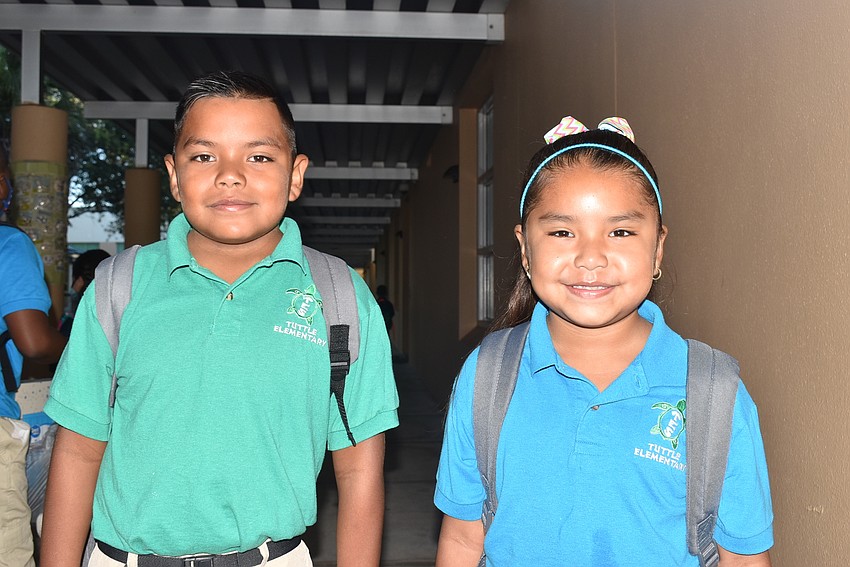 Fourth-grader Abraham Esposa and second-grader Delilah Esposa head to class after saying goodbye to parents at Tuttle Elementary School.