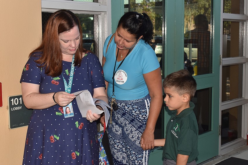 Katie Pac helps Debora and Goao Gustavo find Goao's second-grade class at Tuttle Elementary School.