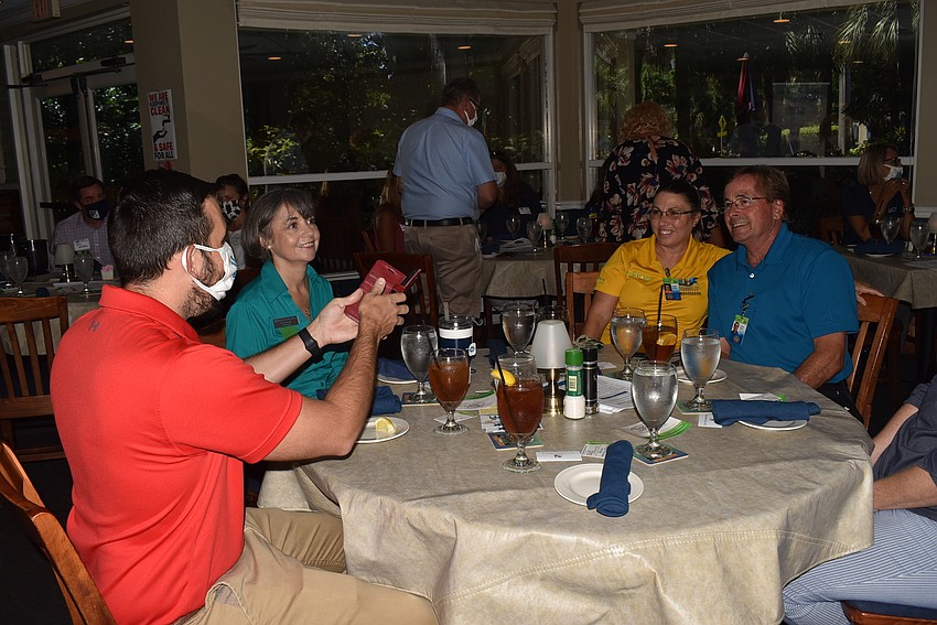 Brandon Vermillion snaps a photo at his table as everyone gets settled for the meeting.