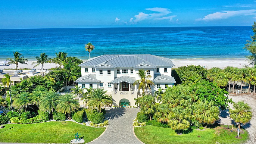 The three-level home features an elevator and a motor court alongside its six car garage, with storage for a golf cart and kayaks or paddleboards.