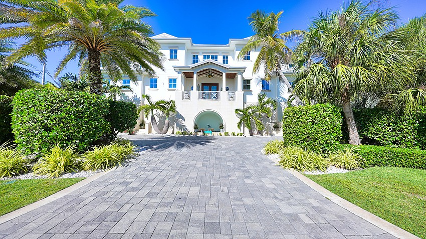 The three-level home features an elevator and a motor court alongside its six car garage, with storage for a golf cart and kayaks or paddleboards.