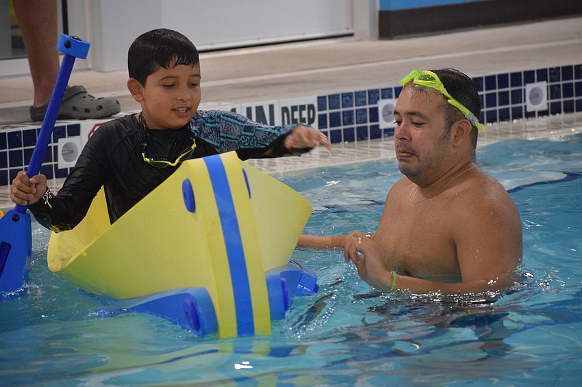 Sarasota's Mathias Lucena, who is 9, paddles in a boat alongside his dad, Alfredo Lucena.