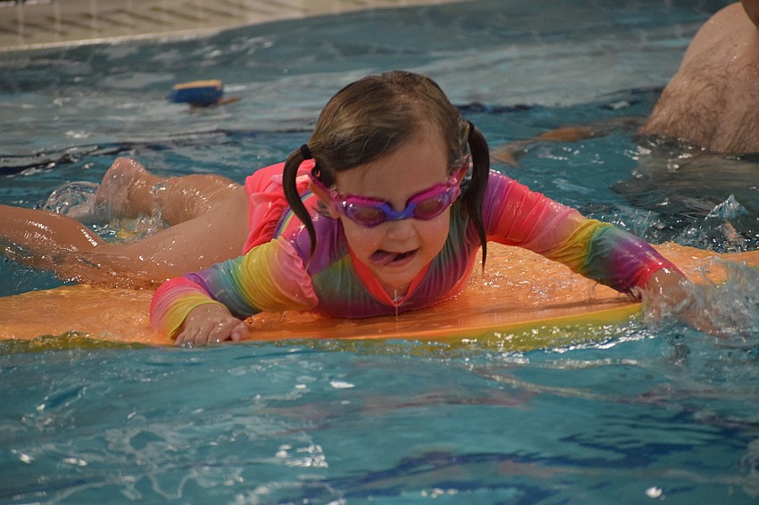 Lakewood Ranch's Allie Selvog climbs onto a pool toy. Selvog loves swimming.