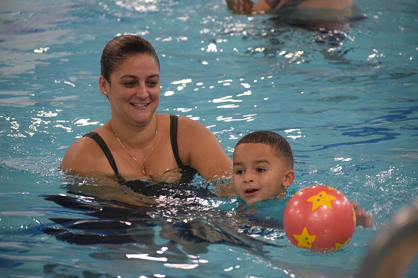 Lakewood Ranch's Valentina Ramirez helps her 3-year-old son Jhomarlin Morillo swim and play around the pool. 