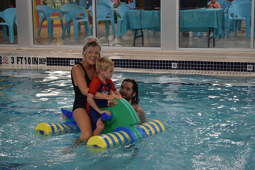 East County's Carrie Ellis rides on a pool toy with her 4-year-old son Keegan Goings while her fiance Mark Baker pushes them along in the pool.