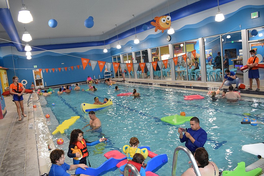 Families spend time in the pool playing with the different pool toys Goldfish Swim School provides.