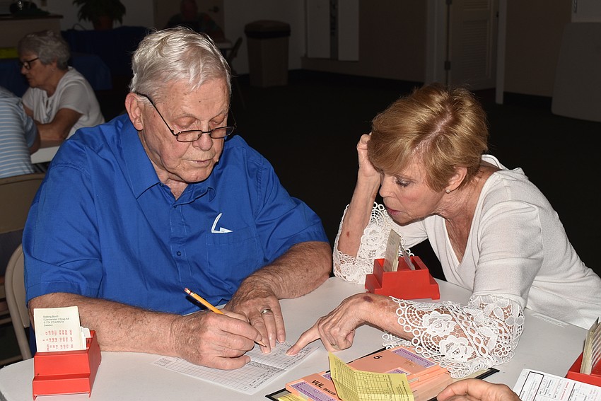 Dick Carlson accepts help from Roberta Shander on how to fill out the contract card.