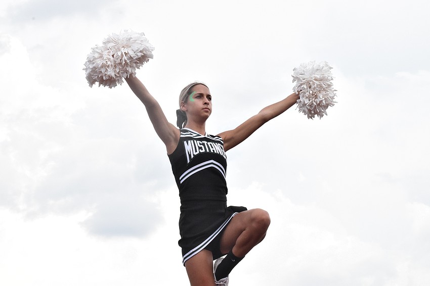 Charlize Ucciferri shakes her pom poms as a 