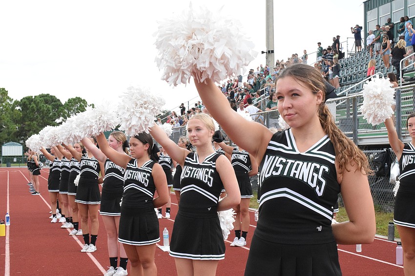Cheerleaders Rylin Ferber, Audra Rappold and Kennedy Burnette line up and raise their pom poms to the jumbotron as the Lakewood Ranch High School Marching Mustangs play the school's alma mater.