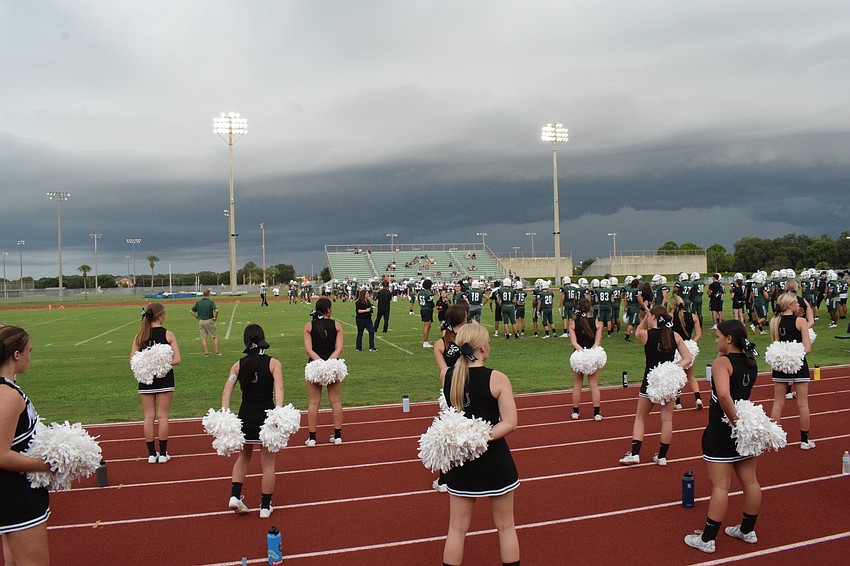 Lakewood Ranch High cheerleaders stand on the track as the football game begins.