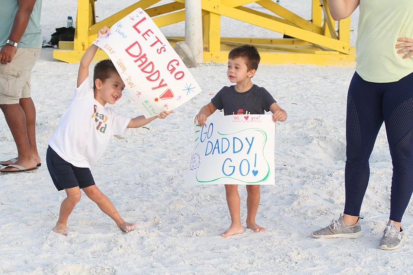 Perry and Ari Newman cheer on their dad Quincy Newman.