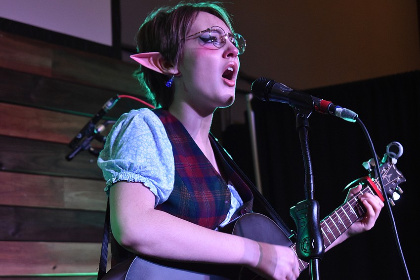 Grace Johnson plays guitar for a crowd.