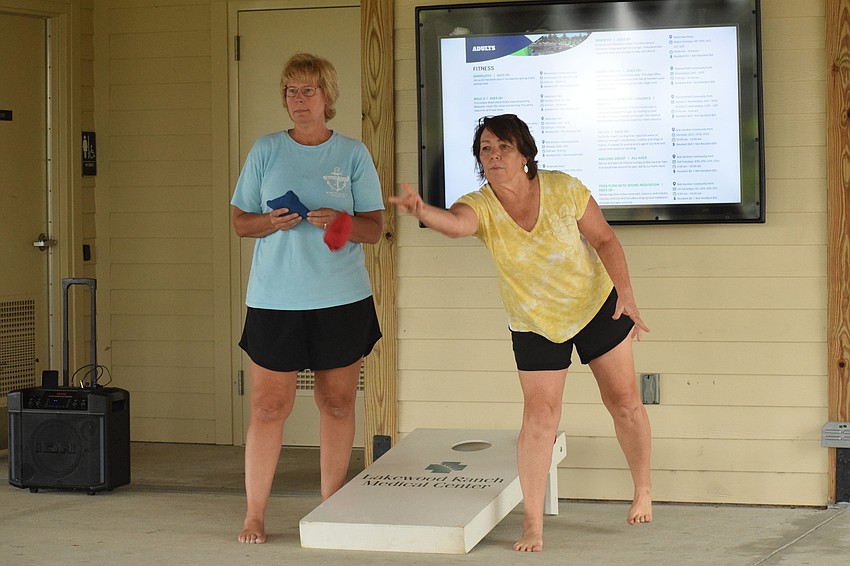 Lakewood Ranch's Kelly Harmon competes against Carolyn Ray in a game of cornhole.